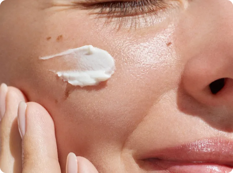 Woman applying lotion to face